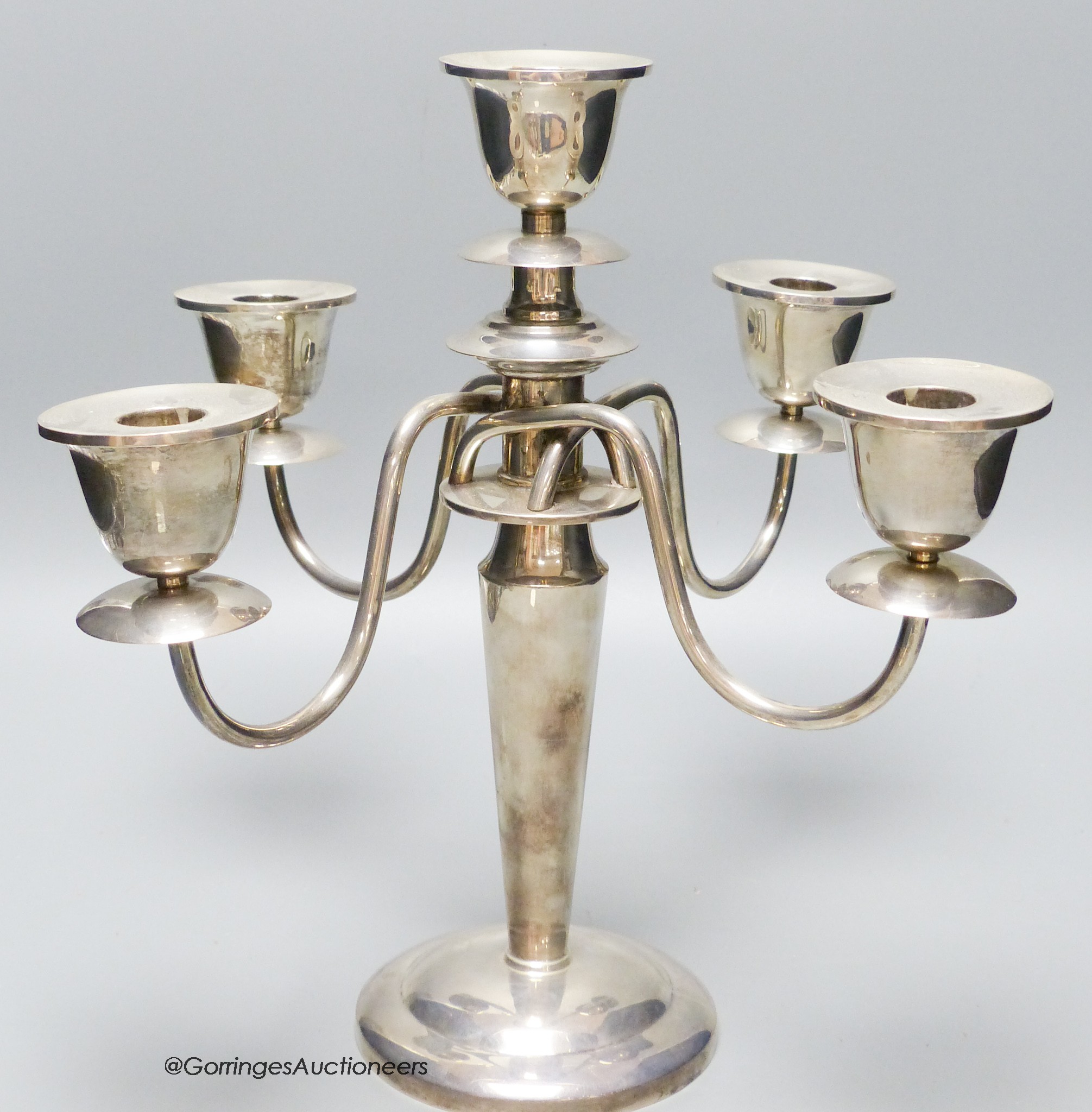 A white metal (stamped sterling) four branch, five light candelabrum, height 30.4cm, gross weight 36.5oz.